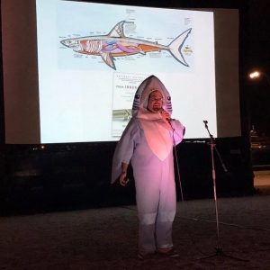 Dr. David Shiffman hosts a talk on stage wearing a shark costume.